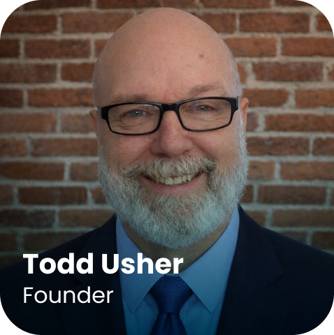 A man with glasses, a white beard, and a bald head in a suit and blue tie smiles in front of a brick wall. Text reads: “Todd Usher, Founder.”.