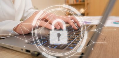 Close-up of hands typing on a laptop keyboard, with a digital padlock and network overlay—symbolizing Remote Staffing Security provided by the right people.